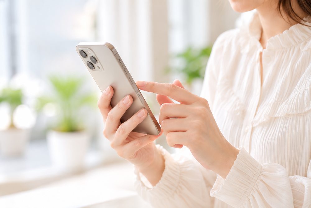 スマートフォンで予約する女性（イメージ）