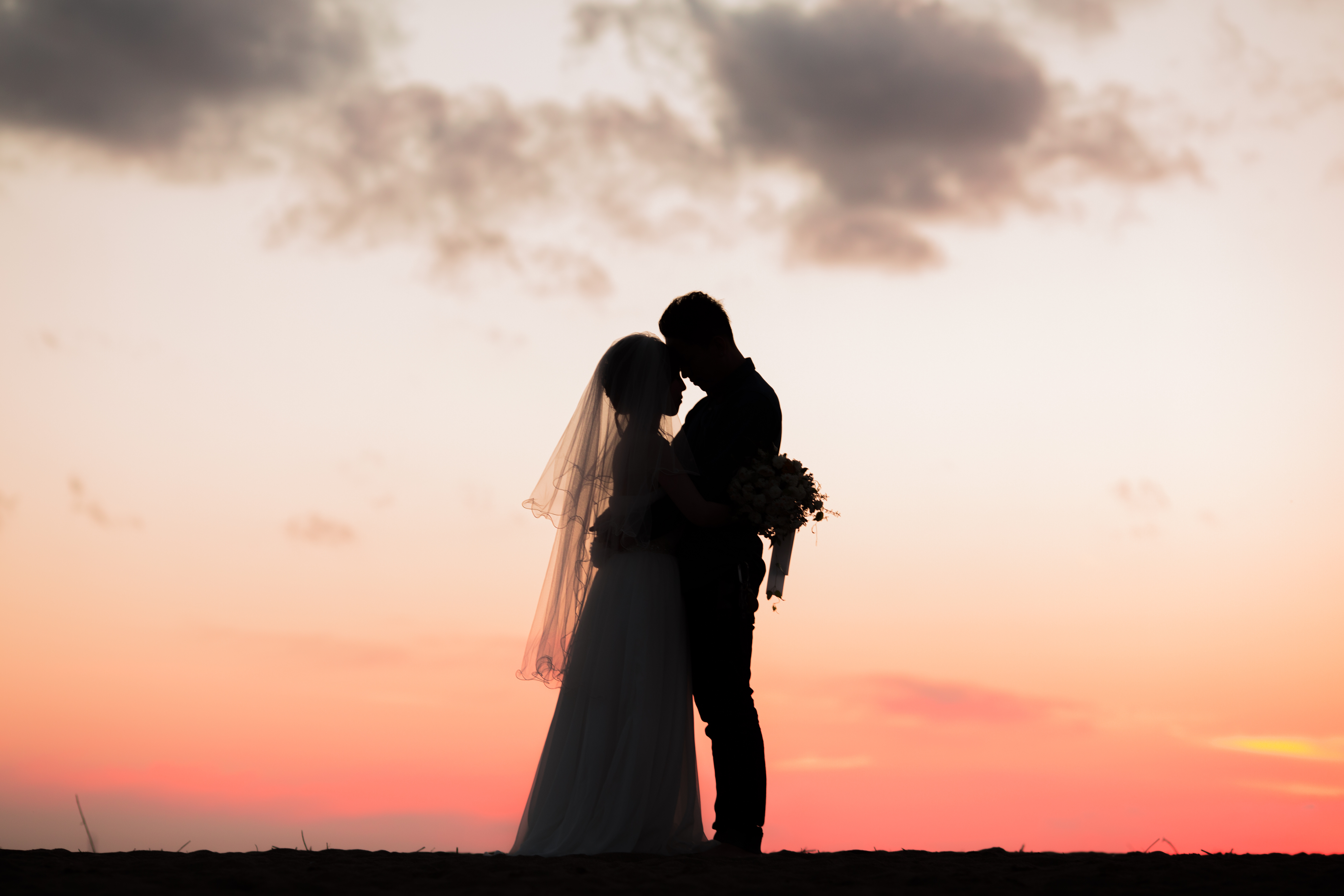 夕暮れに寄り添う新郎新婦のシルエット